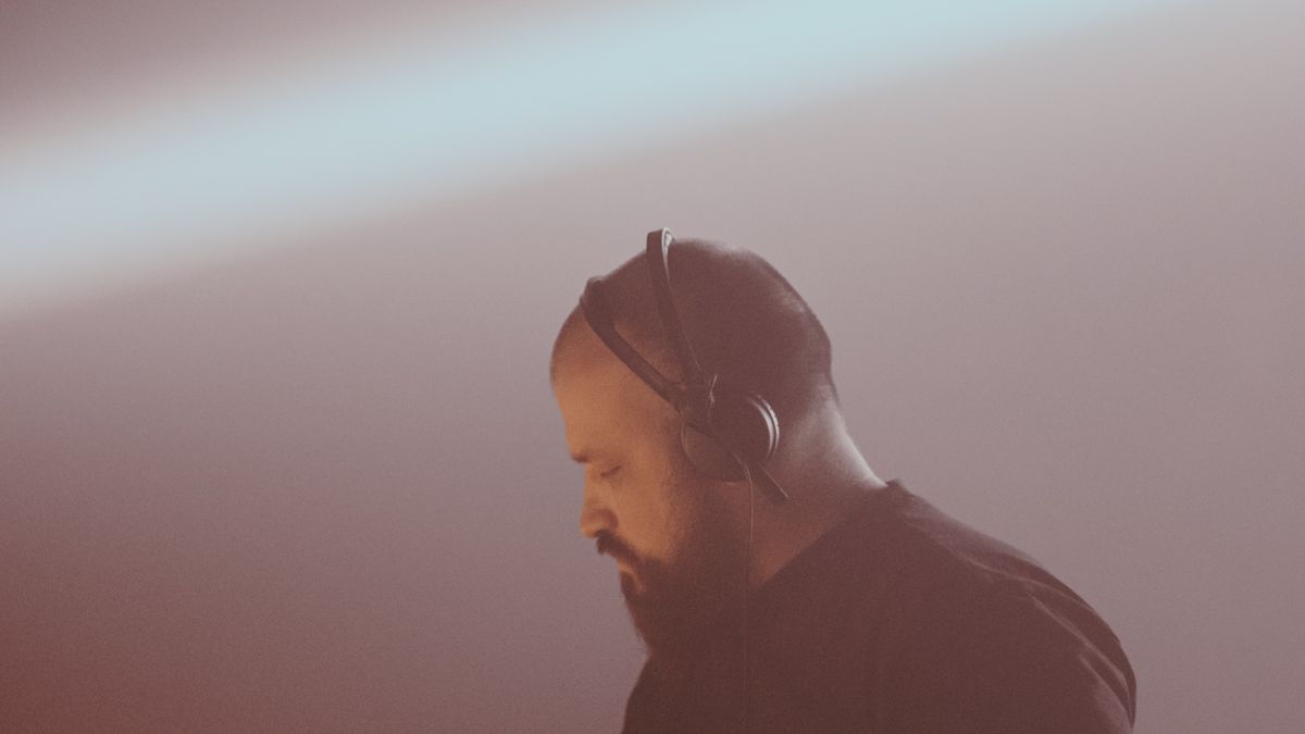 OldGold in headphones, head down, in rose-colored haze